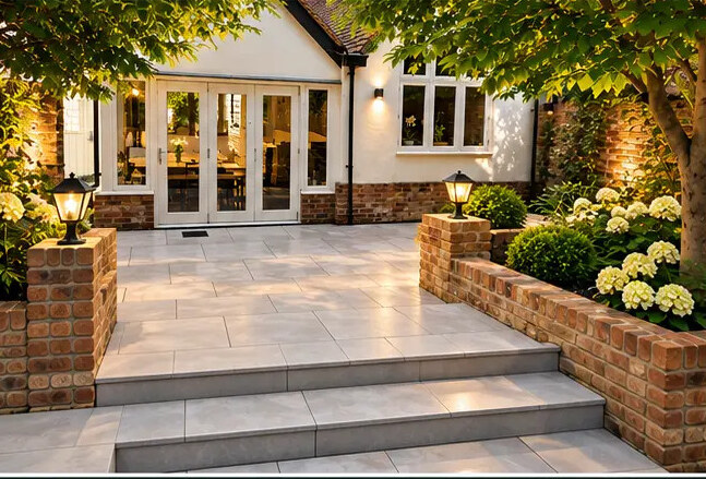 Paved terrace with wide steps, brick raised beds and hydrangea planting